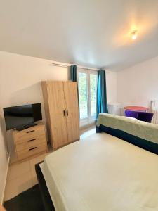 a small room with two beds and a television at Maison Bon Séjour in Livry-Gargan +8 photos