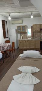 a room with two beds and a kitchen with a table at Eleonoras House in Leonidio