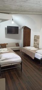 a room with two beds and a flat screen tv at Eleonoras House in Leonidio