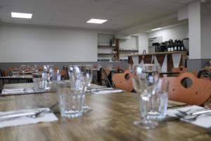 Un comedor con vasos sobre una mesa de madera en Espace Gerbier, en Sainte-Eulalie 14 fotos más