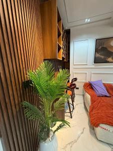 um quarto com uma planta num vaso ao lado de uma cama em Palm & Pearl Apartment em Lekki