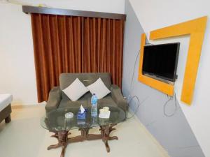 a living room with a couch and a table and a television at Royal Ilva Hotel in Lahore +29 photos
