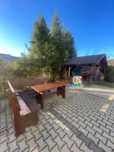 a picnic table and bench on a brick patio at Dom Wiślańskie Wzgórze in Wisła