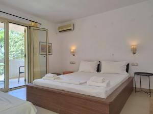 ein Schlafzimmer mit einem Bett, auf dem zwei Handtücher liegen in der Unterkunft Esperides Hotel in Limenas