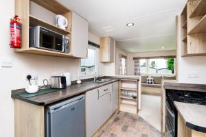 een keuken met een spoelbak en een aanrechtblad bij 3 Bedroom Caravan - Seton Sands in Port Seton