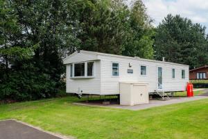 een witte aanhangwagen geparkeerd in een tuin met een gazon bij 3 Bedroom Caravan - Seton Sands in Port Seton