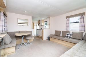 een woonkamer met een bank en een tafel bij 3 Bedroom Caravan - Seton Sands in Port Seton