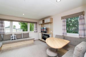 een woonkamer met een bank en een tafel bij 3 Bedroom Caravan - Seton Sands in Port Seton