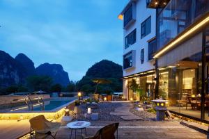 a hotel with a swimming pool and a building at Yangshuo The One Hotel- Aesthetic Lifestyle in Yangshuo