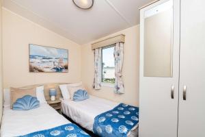 a small room with two beds and a window at 3Bedroom Caravan Seton Sands in Port Seton
