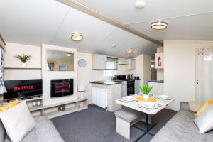 a living room with a table and a kitchen at 3Bedroom Caravan Seton Sands in Port Seton