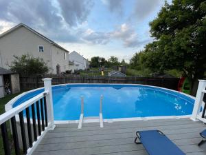 a large blue swimming pool on a wooden deck at Cozy boho Retreat in Grove City