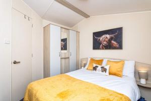 a bedroom with a bed and a painting of a cow at 3Bedroom Caravan Seton Sands in Port Seton +17 photos