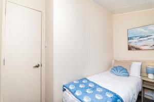 a small bedroom with a bed with a blue blanket at 3Bedroom Caravan Seton Sands in Port Seton