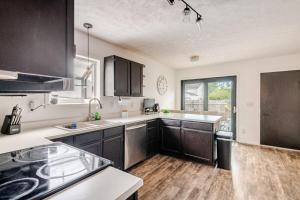 a kitchen with black cabinets and a large window at Cozy boho Retreat in Grove City