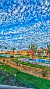uma vista para um resort com uma piscina e palmeiras em Elabd Family Porto Chalet em Marsa Matruh