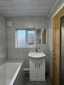 レスターにあるSerenity LTDのバスルーム(シンク、バスタブ、鏡付)