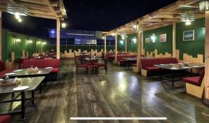 a dining room with tables and red chairs at Hotel Blue Bird in Jaipur