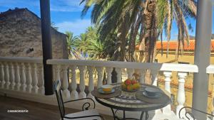 バジェエルモソにあるVv Casa Zoila A 15 Minutos del Garajonayのヤシの木が植えられたバルコニーに果物を添えたテーブル