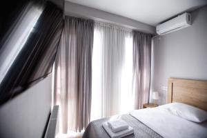 a bedroom with a bed and a large window at GGM apartment in Kutaisi