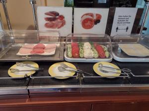 un bufé con platos de comida y utensilios en HOTEL S Norderstedt, en Norderstedt