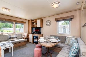 a living room with a couch and a table at 3 Bed Caravan - Seton Sands in Port Seton