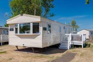 a white tiny house parked in a yard at 3 Bed Caravan - Seton Sands in Port Seton
