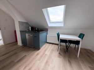 a kitchen with a table and chairs and a window at Bothfeld Suite in Hannover
