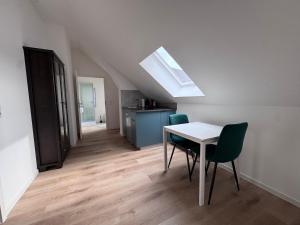 a room with a table and chairs and a kitchen at Bothfeld Suite in Hannover