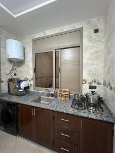 a kitchen with a sink and a stove and a window at Sahara luxury suites in Hassilabied