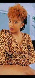 恩德培Airport View International Hotel Uganda的一名身穿豹纹衬衫、双臂交叉的女子