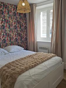 a bedroom with a bed with a patterned wall at Appartement coquet à la Machine in La Machine