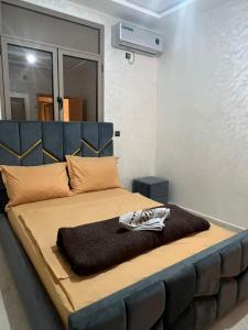 a bedroom with a large bed with a blue headboard at Sahara luxury suites in Hassilabied