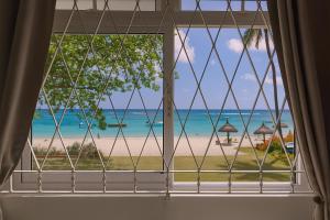 a window with a view of the beach at Serge's Beachfront by Serenity in Trou aux Biches