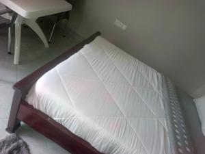 a bed in the corner of a room with a desk at Guardian Motel Kasese in Kasese