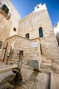 ein Backsteingebäude mit einem Turm, auf dem ein Schild angebracht ist in der Unterkunft Lyon Vischi in Trani + 12 Fotos