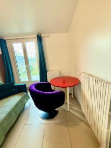 a living room with a purple chair and a table at Maison Bon Séjour in Livry-Gargan
