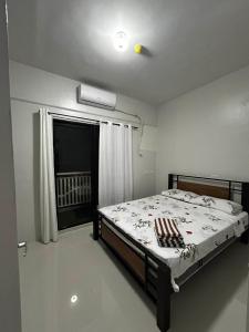 a bedroom with a bed and a window at Azure Edge in Dauis