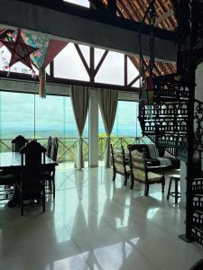 a room with a table and chairs and a large window at Gravata Paradise in Gravatá