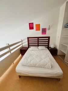 ein Bett in einem Schlafzimmer mit Schildern an der Wand in der Unterkunft T2 4 couchages Port du Cap d'Agde , climatisation , piscine in Cap d'Agde + 5 Fotos