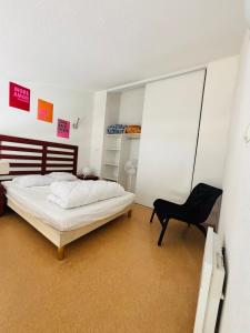 ein Schlafzimmer mit einem Bett und einem Stuhl darin in der Unterkunft T2 4 couchages Port du Cap d'Agde , climatisation , piscine in Cap d'Agde