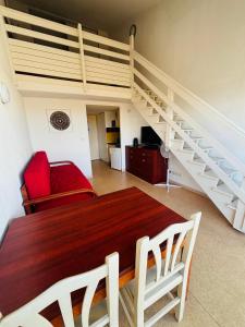 ein Wohnzimmer mit einem Esstisch und einer Treppe in der Unterkunft T2 4 couchages Port du Cap d'Agde , climatisation , piscine in Cap d'Agde