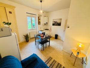 Una sala de estar con un sofá azul y una mesa. en Le pied à terre - Centre ville - Montceau-les-mines, en Montceau-les-Mines