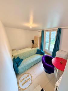 ein Schlafzimmer mit einem Bett und einem lila Stuhl in der Unterkunft Maison Bon Séjour in Livry-Gargan