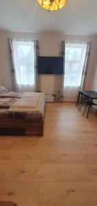 une chambre avec deux lits, une table et deux fenêtres dans l'établissement Comfy & Cozy Studio near Enkplatz U3, à Vienne