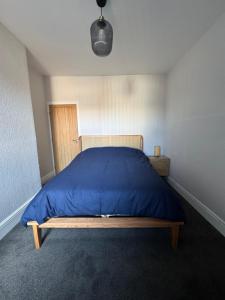 レスターにあるSerenity LTDの青い掛け布団が敷かれたベッドのある寝室