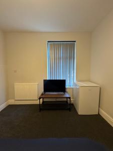 レスターにあるSerenity LTDの窓の前のテーブルにノートパソコンが備わるお部屋