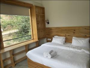 ダルムシャーラにあるShepherds Of Dharamshalaのベッドが2つと大きな窓がある寝室