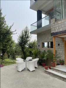 ダルムシャーラにあるShepherds Of Dharamshalaの家の前のパティオ(白いテーブルと椅子付)