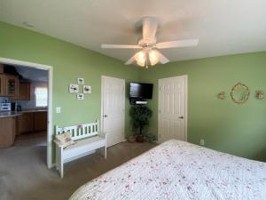 a bedroom with green walls and a ceiling fan at Serendipity in Saint Ignace